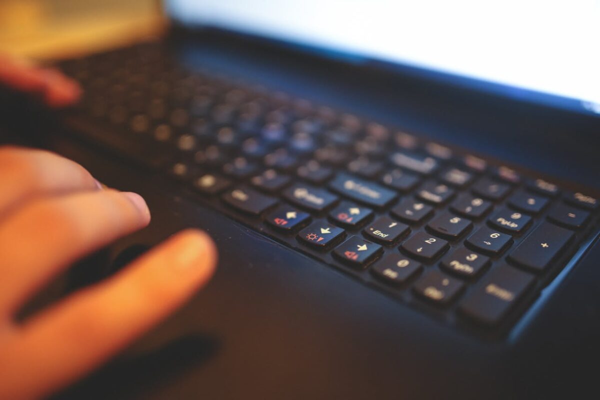 Blurred close-up of hands typing on a laptop keyboard, capturing a focused work moment.